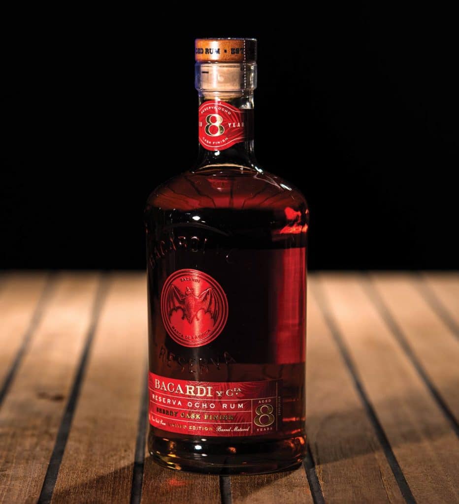 Bacardi Reserva Ocho Años on a wooden table with a black background.