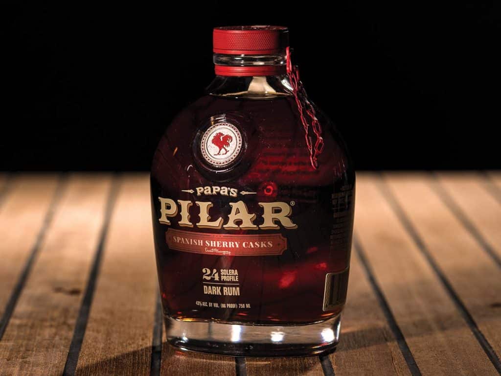 Papa’s Pilar Spanish Sherry Cask on a wooden table with a black background.