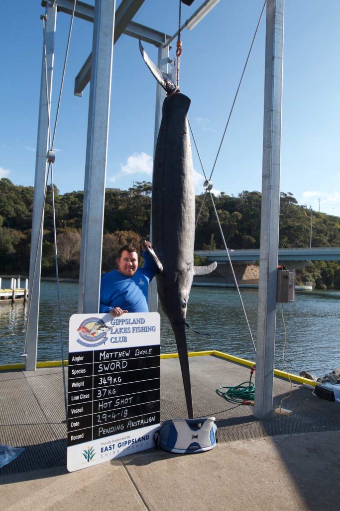 angler standing next to a giant australian swordfish
