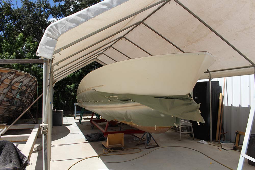 Boat hull under construction under a tent