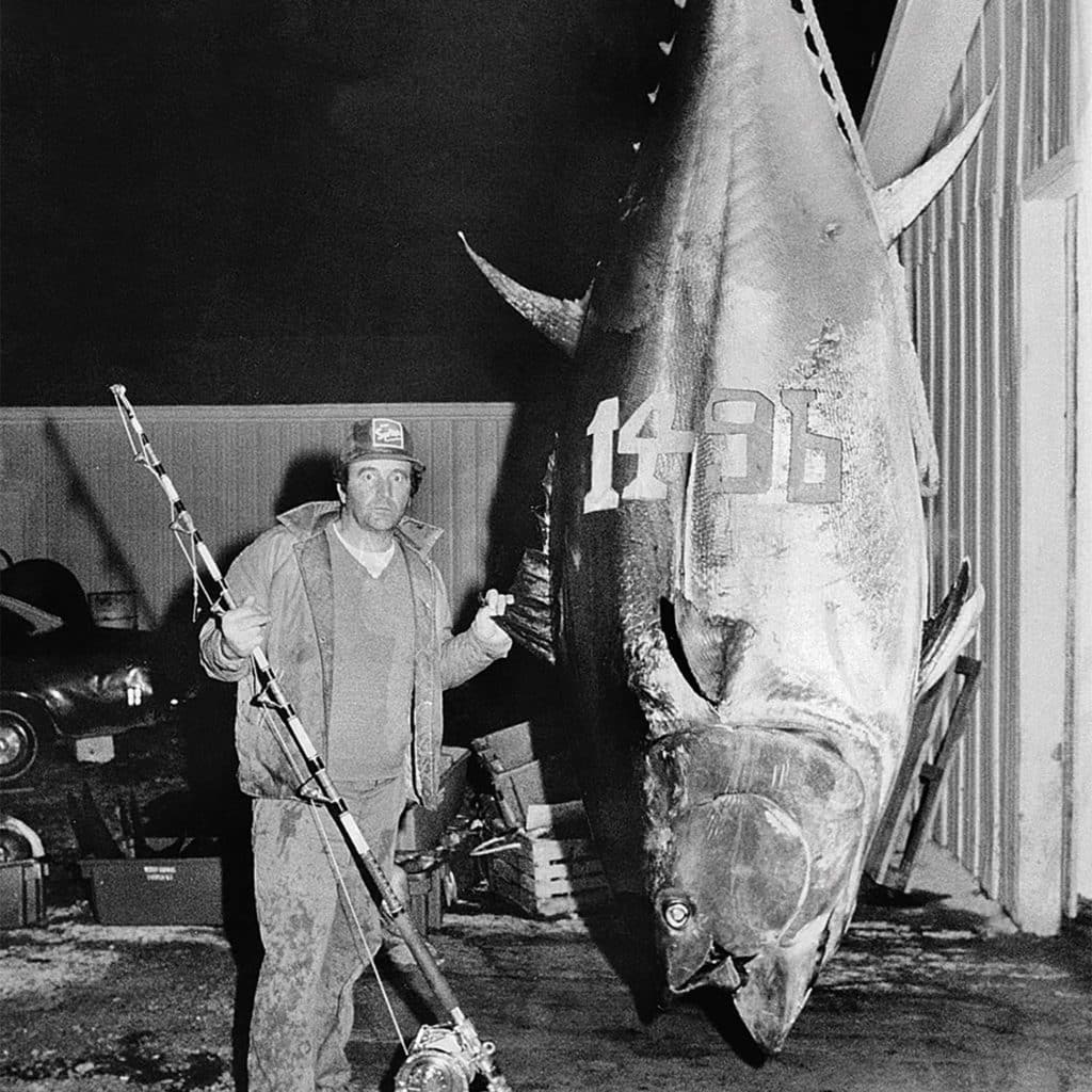 A man stands next to a large bluefin tuna.