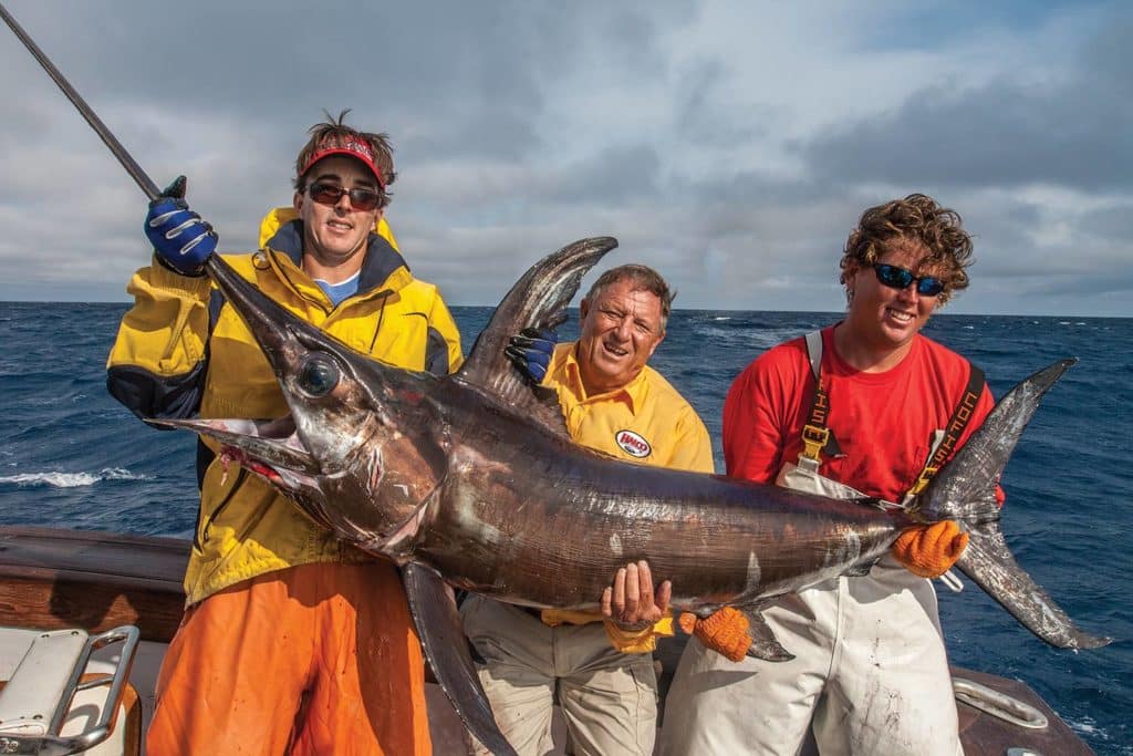 Three anglers holding up a swordfish