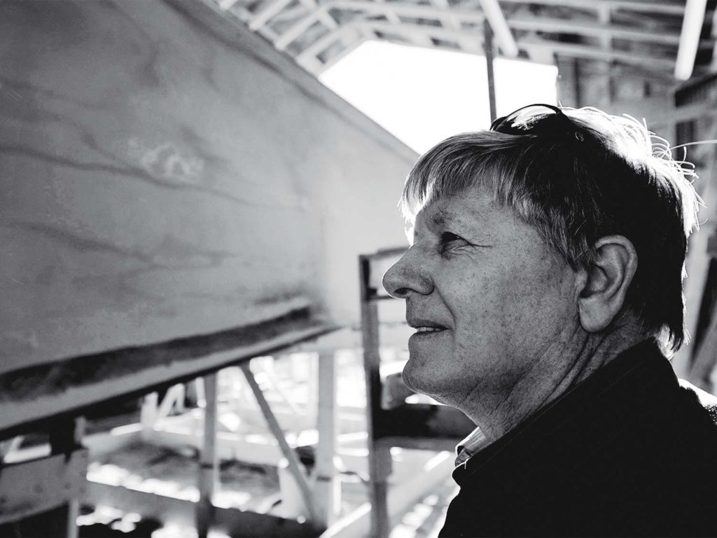 A black and white photo of Paul Spencer in a boatyard.