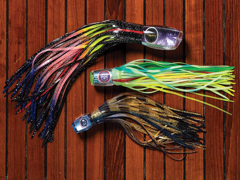 three blue marlin fishing lures on a wooden backdrop