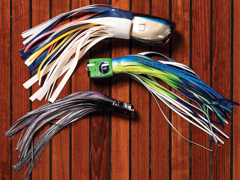 three blue marlin fishing lures on a wooden backdrop