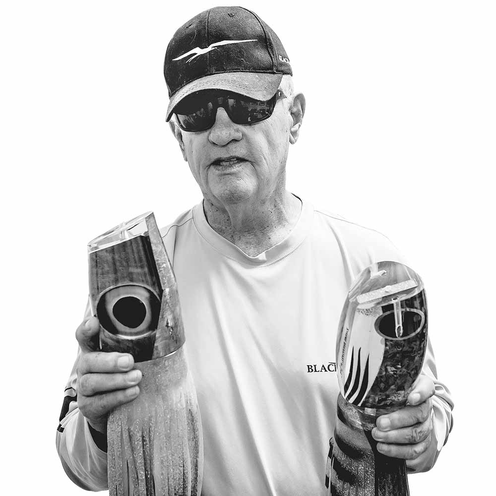 man holding up two marlin fishing lures