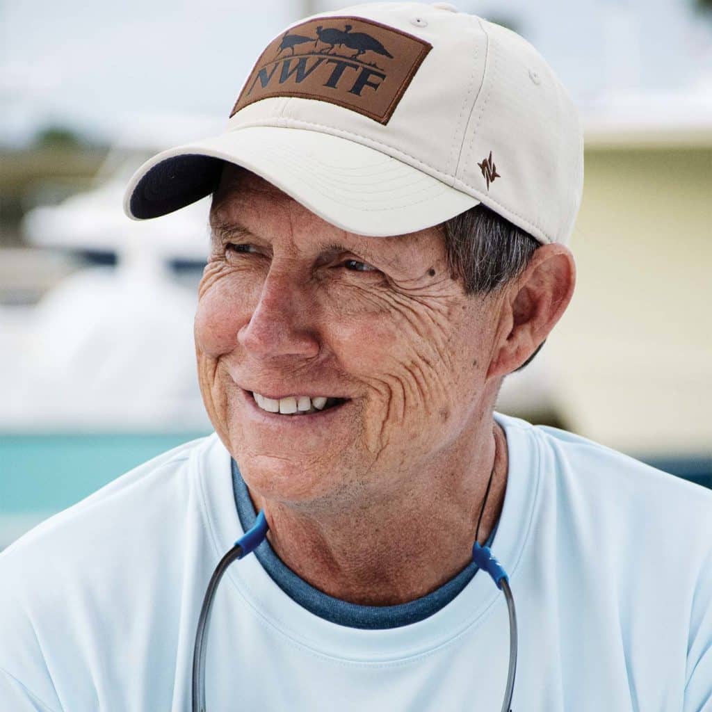 A boat captain wearing a cap and a pair of shades.