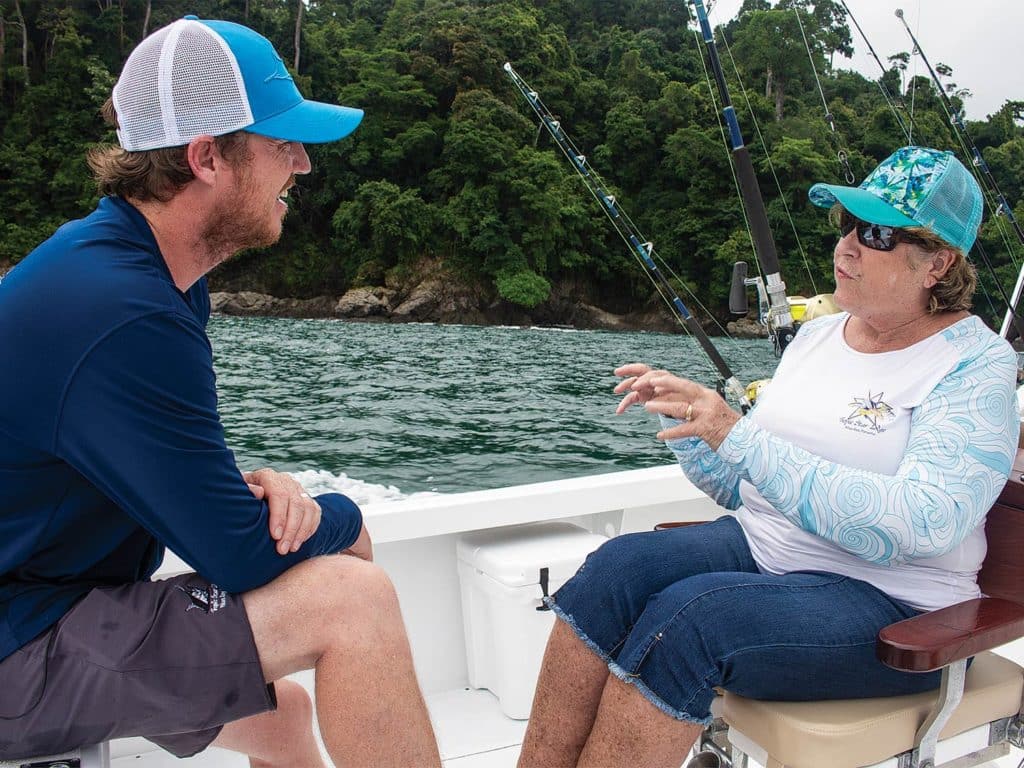 Captain Richard White and Terri Andrews talking on a boat deck.