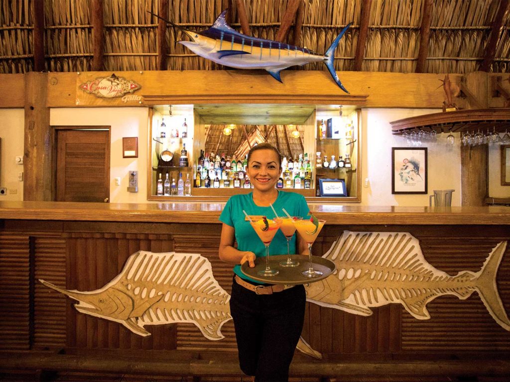 a waitress carrying drinks in Casa Vieja Lodge