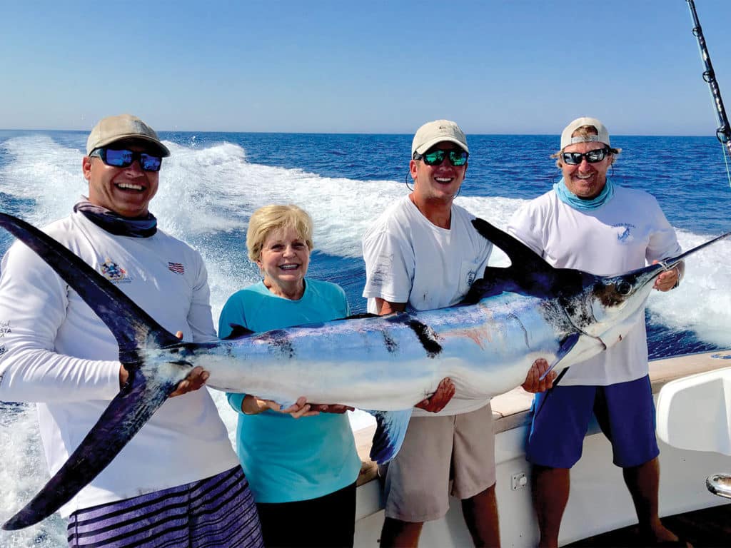 A group of anglers holding up a large white marlin.