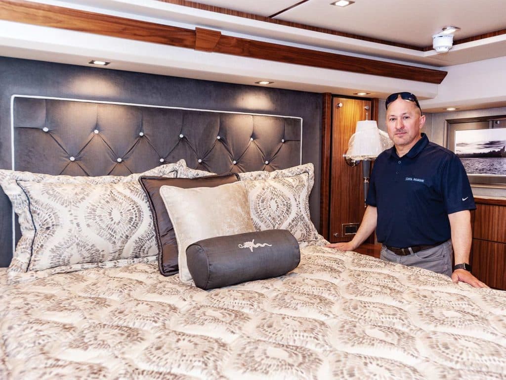 Chris Costa standing by a custom designed bed