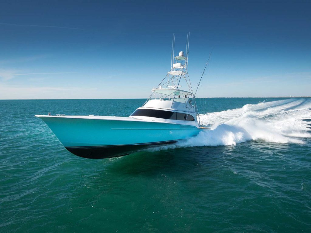 A sport fishing boat races along the water leaving wave crests in its wake.