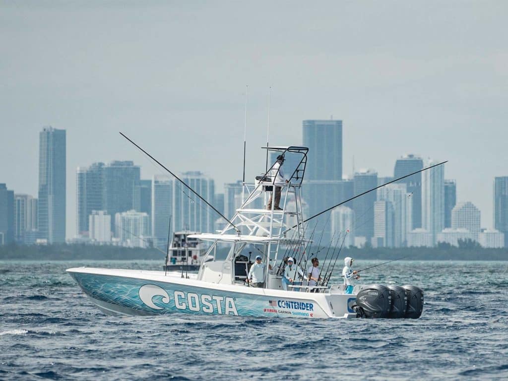A sport fishing boat on the water with the view of the Miami skyline in the background.