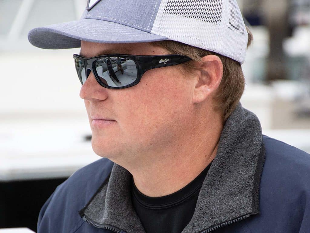 A boat captain wearing a cap and a pair of shades.