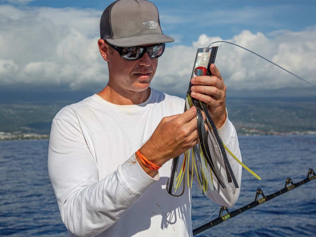 A sport-fisher adjusts a lures hook-set.