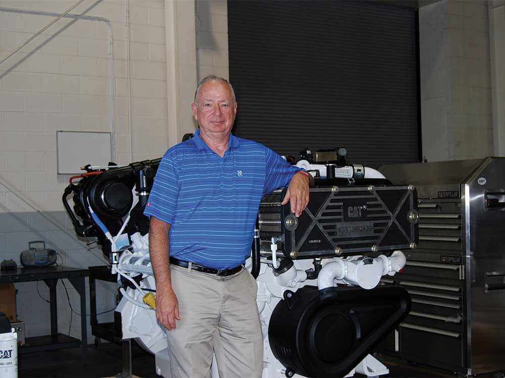 dan webb leaning against caterpillar engine