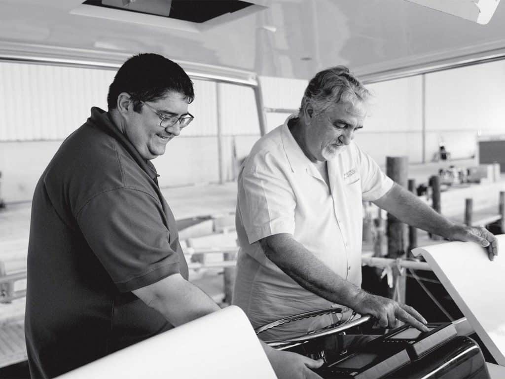 A black and white image of two men on a boat deck.