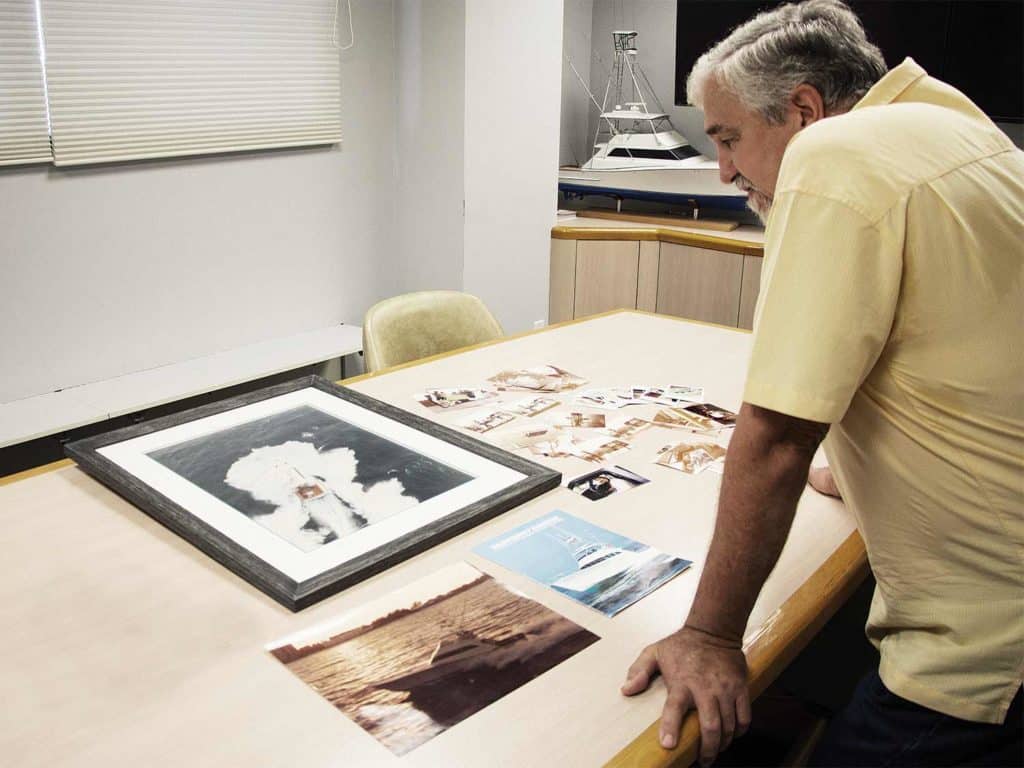 Dominick LaCombe Sr. standing over Monterey print materials