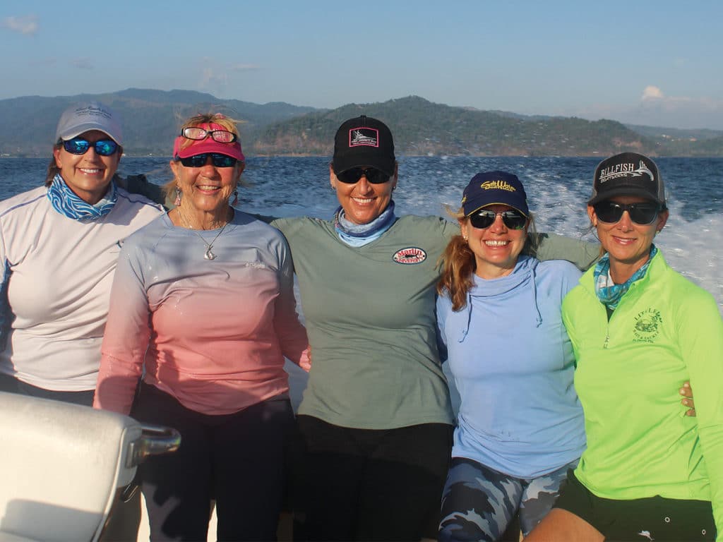 A fishing team of five women on the deck of a sport fishing boat.