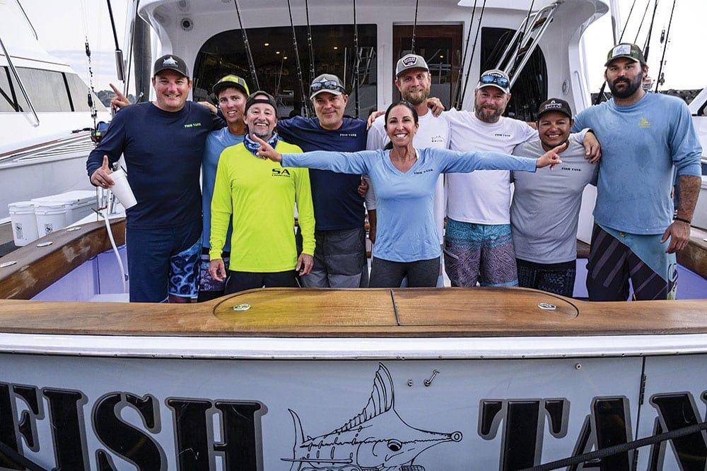 a fishing team standing in the deck of their sport fishing boat