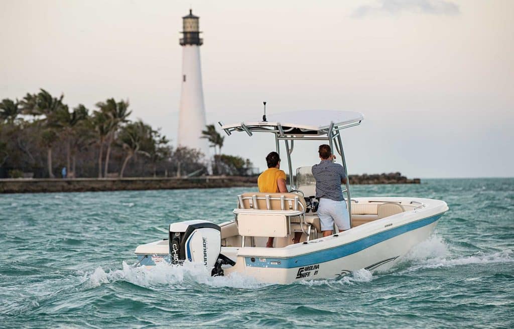 small inshore boat with lighthouse in the distance