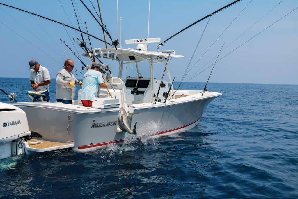 three men fishing on an offshore onboard motor boat