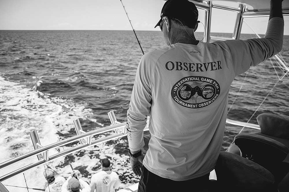 black and white image of fisher on a boat deck