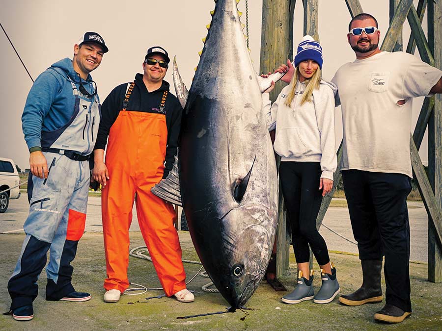 A group of anglers stand around a large bluefin tuna.