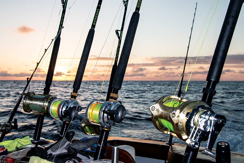 fishing reels on the bow of a boat at sunset