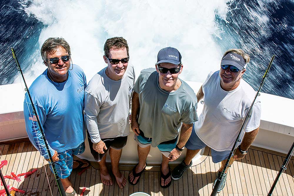 four fishermen standing on a boat deck