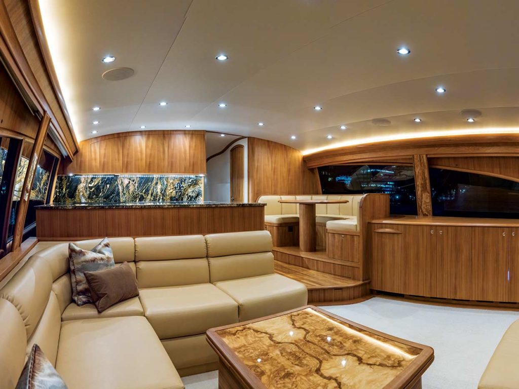 The luxurious interior salon of a sport-fishing boat featuring teak woodwork.