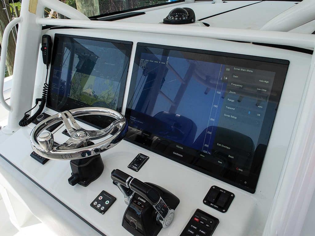 Two displays of Garmin MFDs at the helm of a sport-fishing boat.