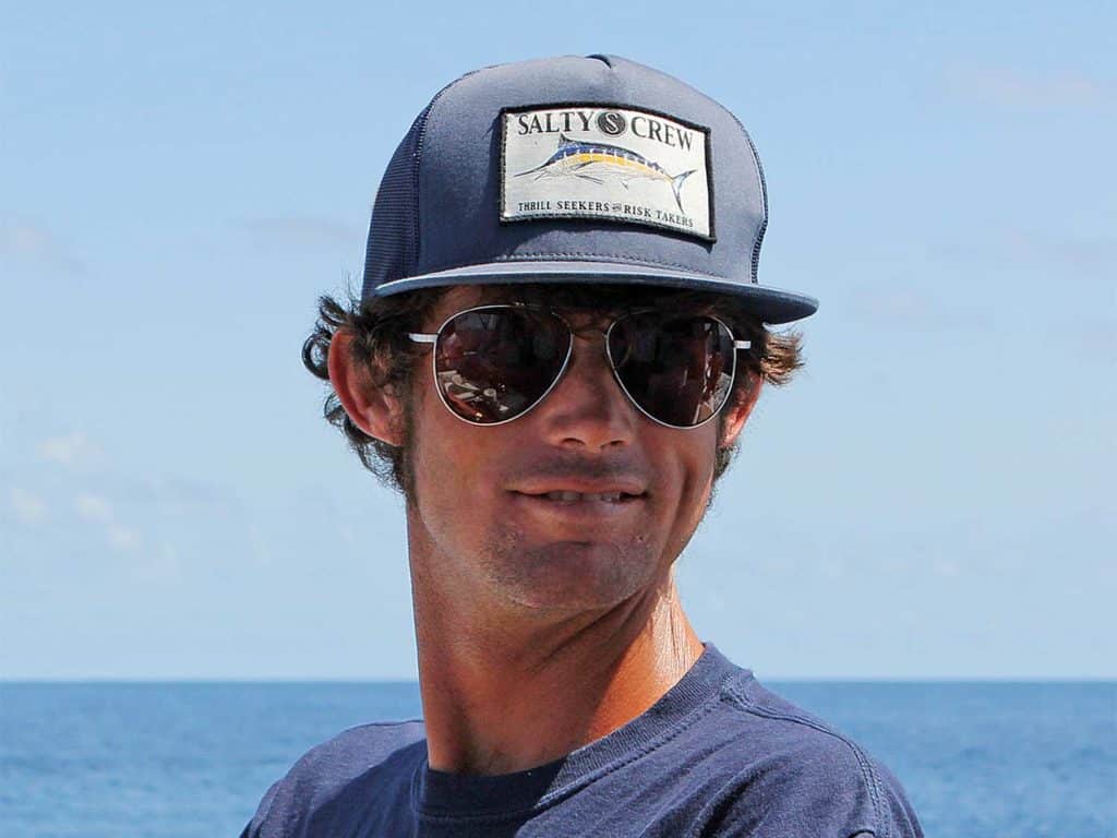 A man wears sunglasses and a hat.