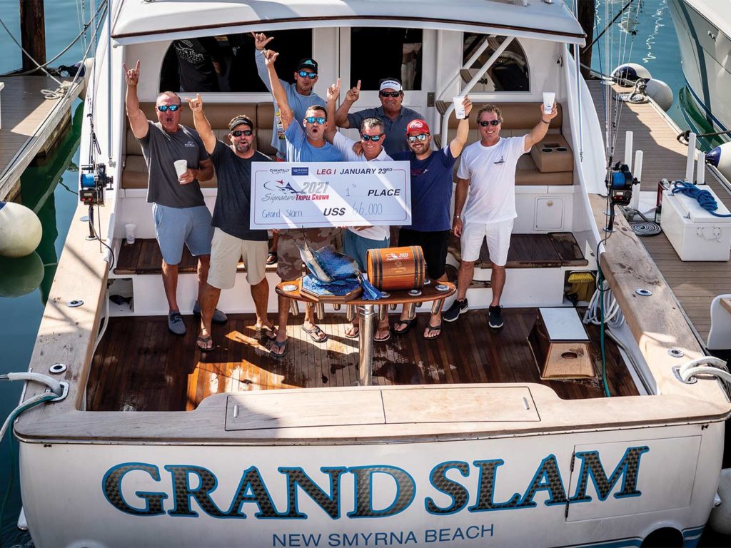 A fishing team standing on the back of a boat.