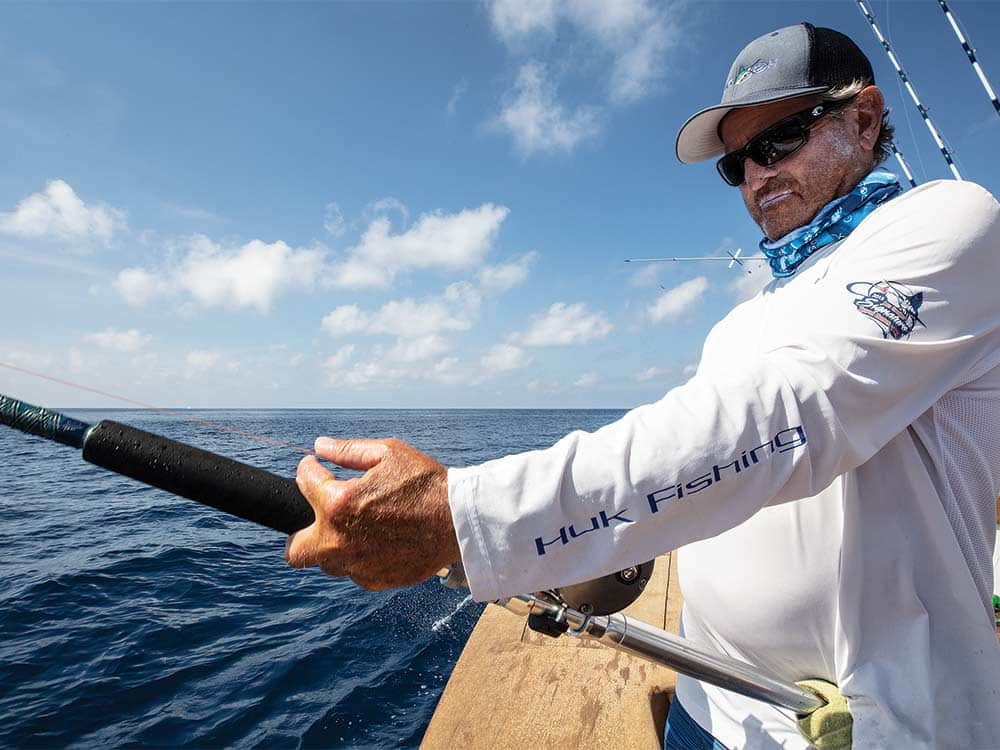 gray ingram fishing off the side of a boat