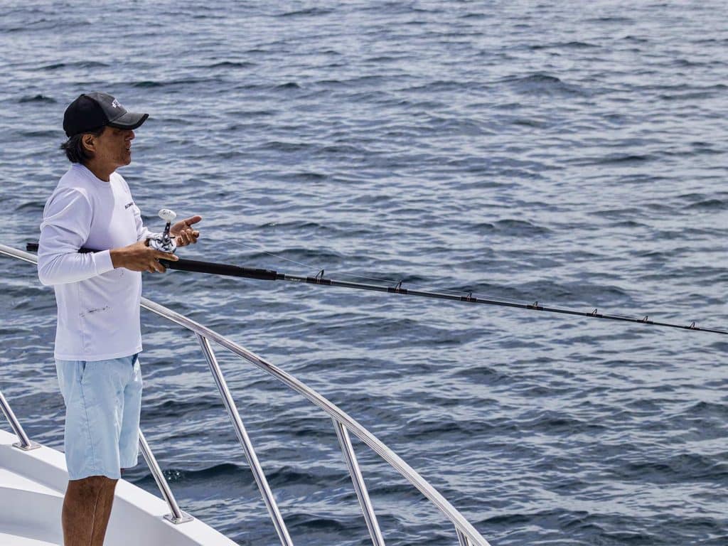 Hsieh fishing off the side of a sport fishing yacht.