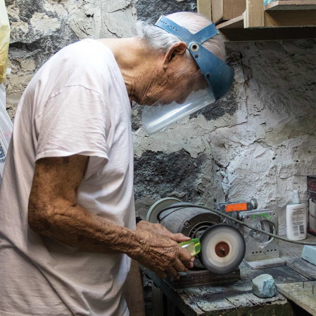 Joe Yee smoothing a hand-crafted marlin lure.