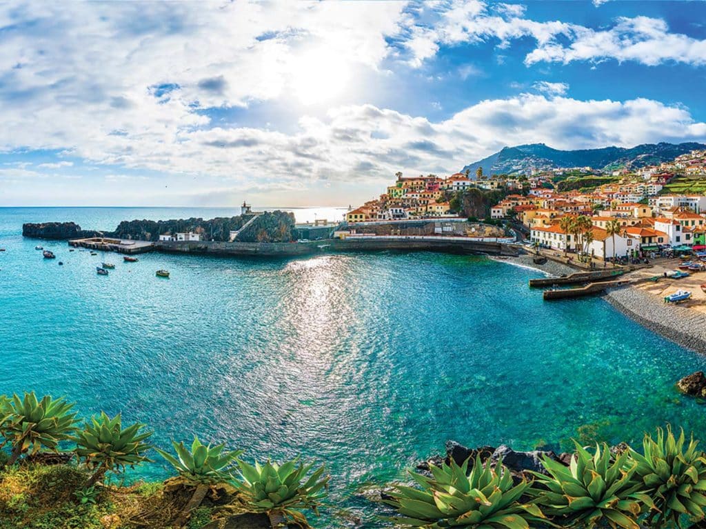 The coastal town of Madeira. City buildings are white with orange roofs.
