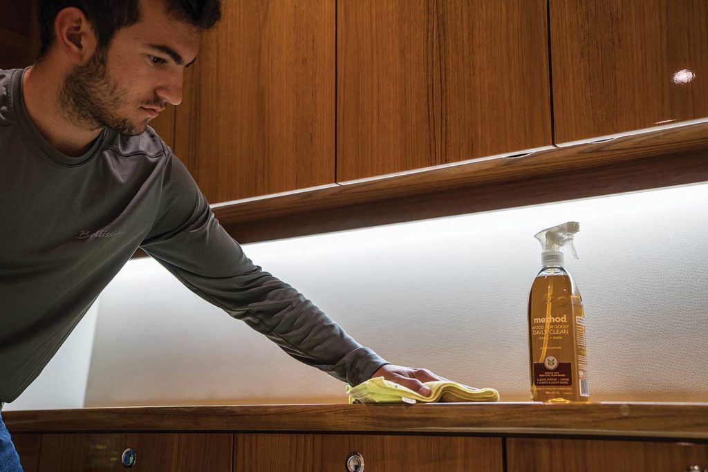 Man polishing a wooden cabinet.