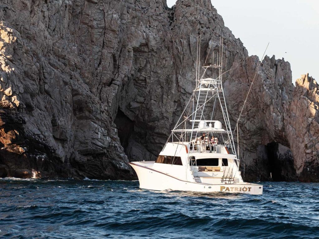 a sport fishing yacht near a cliff side in cabo san lucas