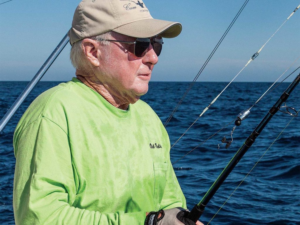 angler in a green shirt fishing on the ocean