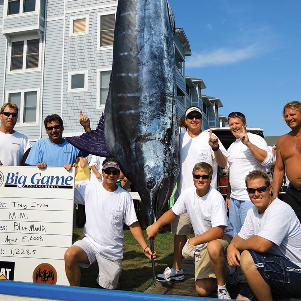 A fishing team stands around a large marlin.