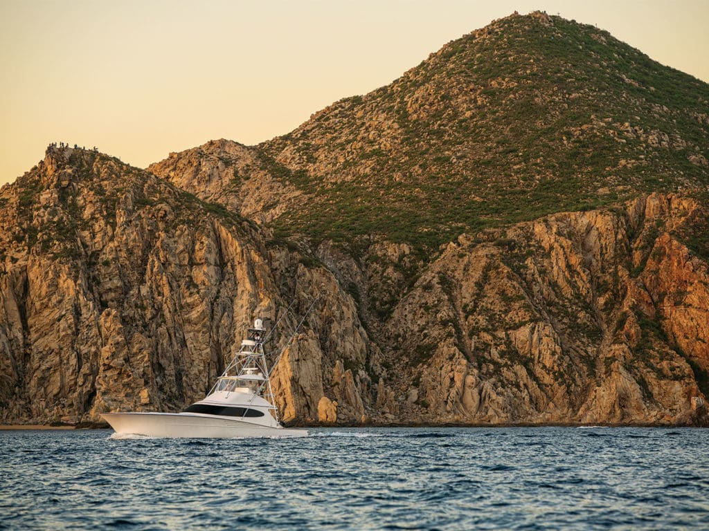 A sport fishing boat on the water at sunset.