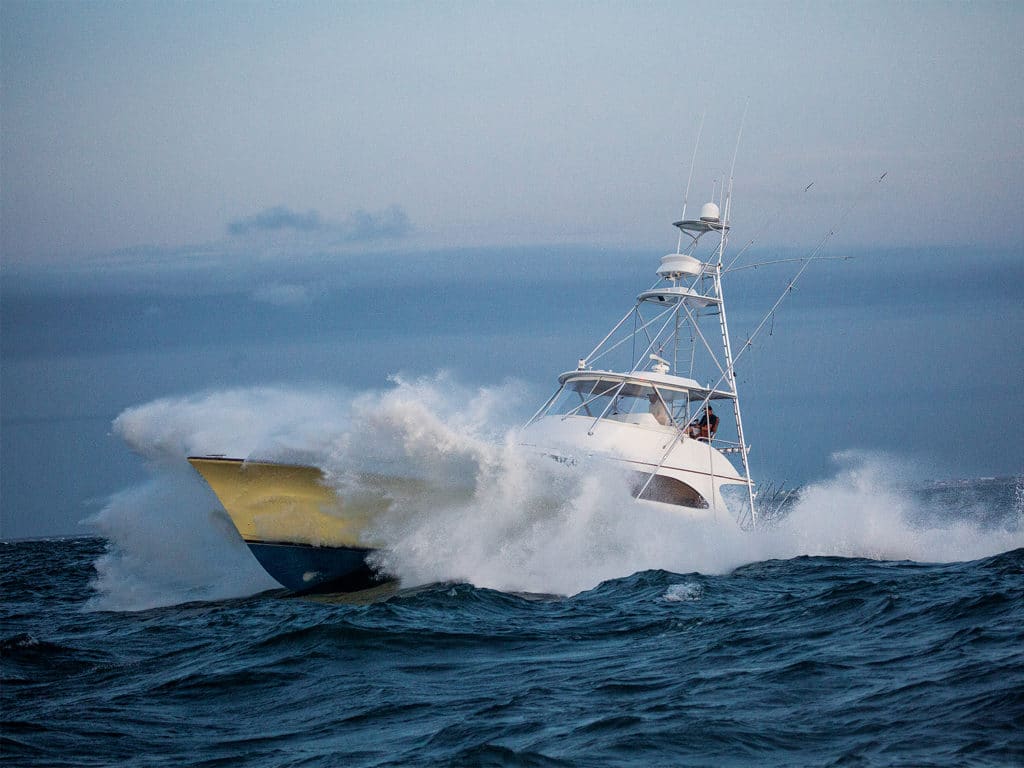A sport-fishing boat crashing through the waves on the water.