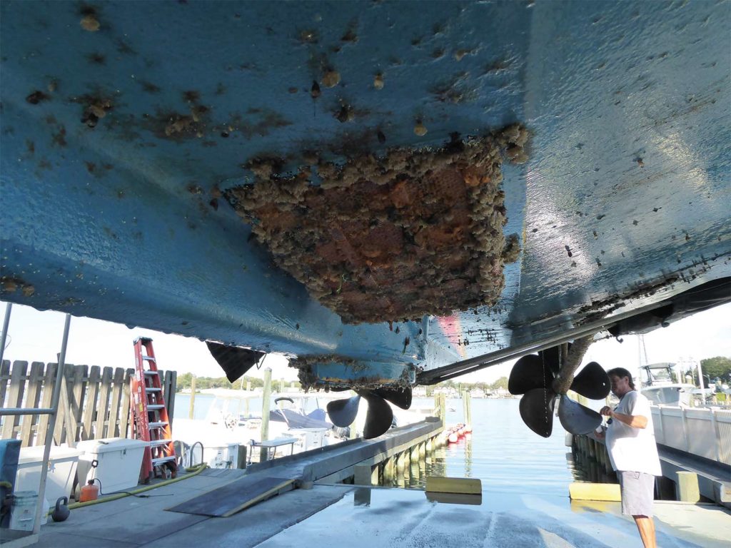 A sport fishing boat undergoing inspection in dry dock.