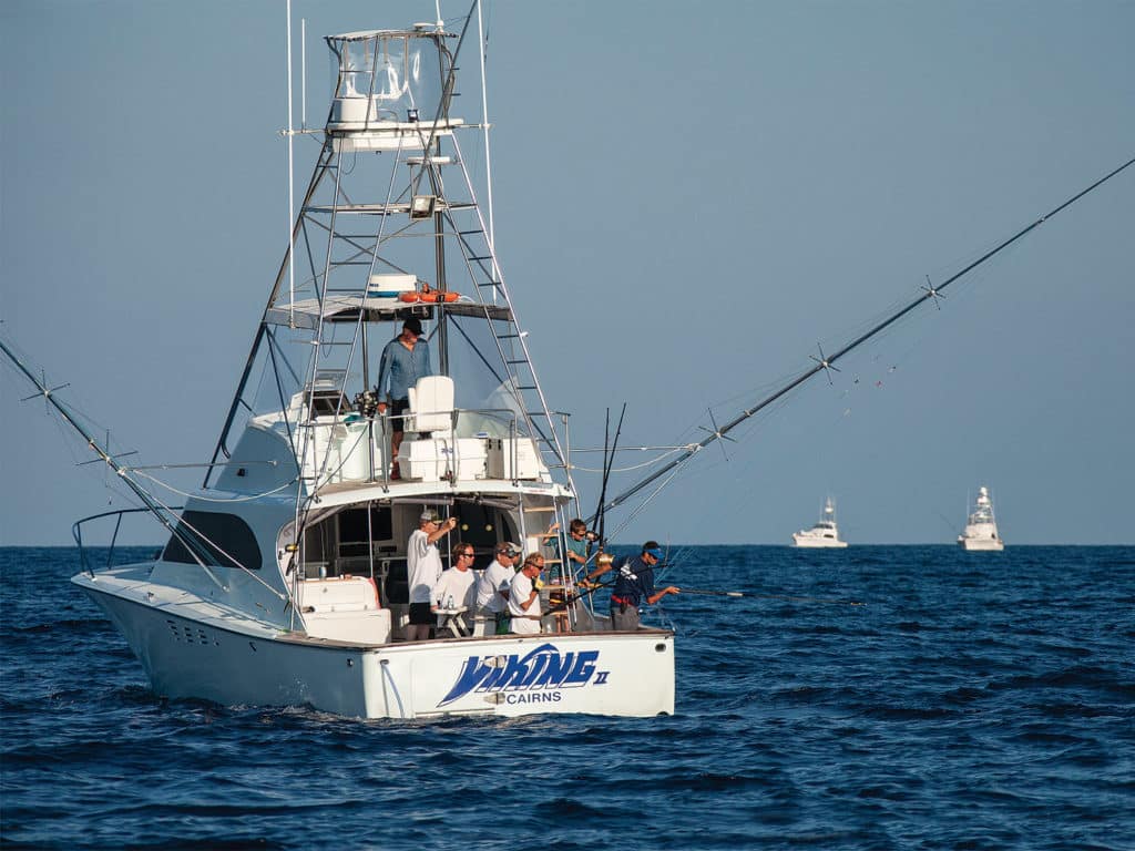 A sport fishing team on the deck of a boat.