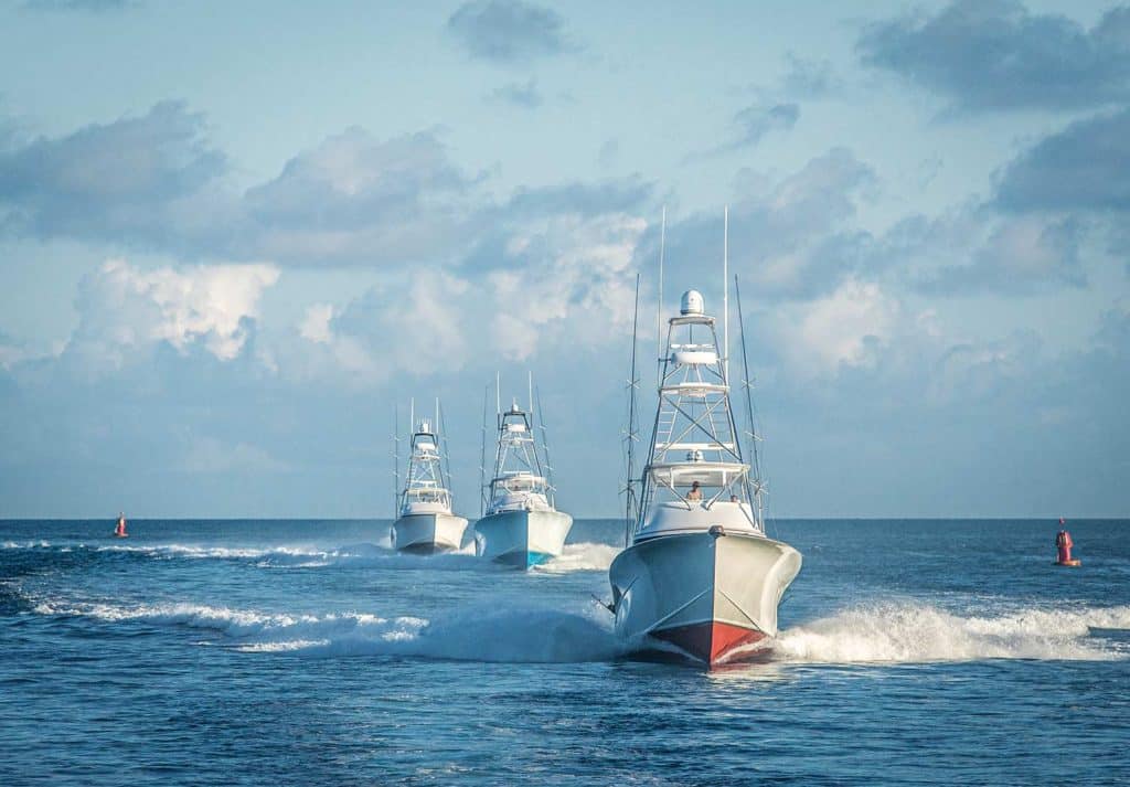Three sport fishing boats out on the open sea.