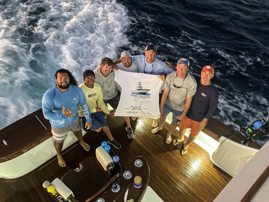 A team of sport fishers holding up a white fishing flag.