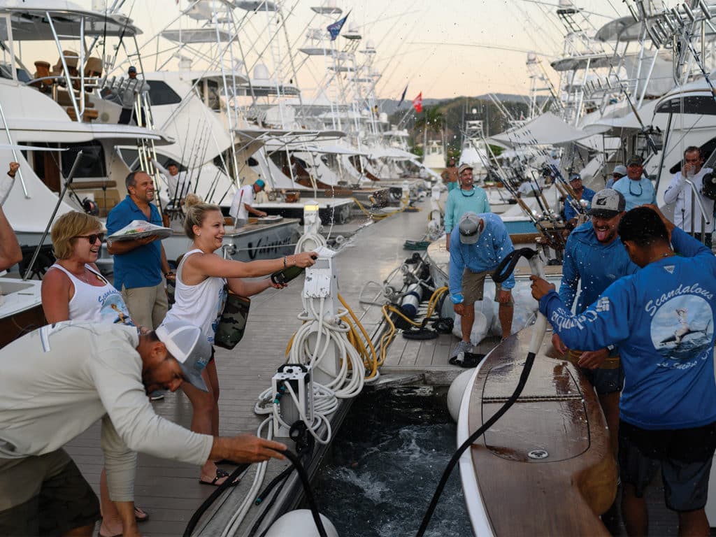 A team of sport-fishers celebrating their tournament day on the docks of a marina.