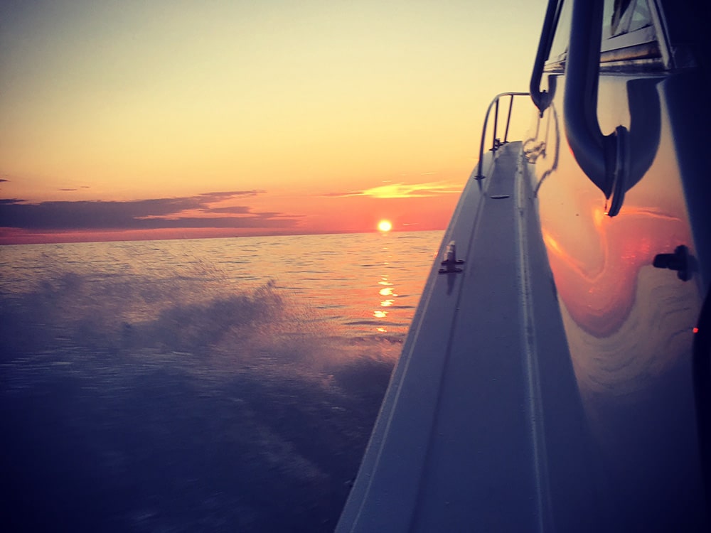 sunrise with boat running